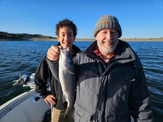 Guide Service, a man and his son showing a striper caught on an EZ U-Rig