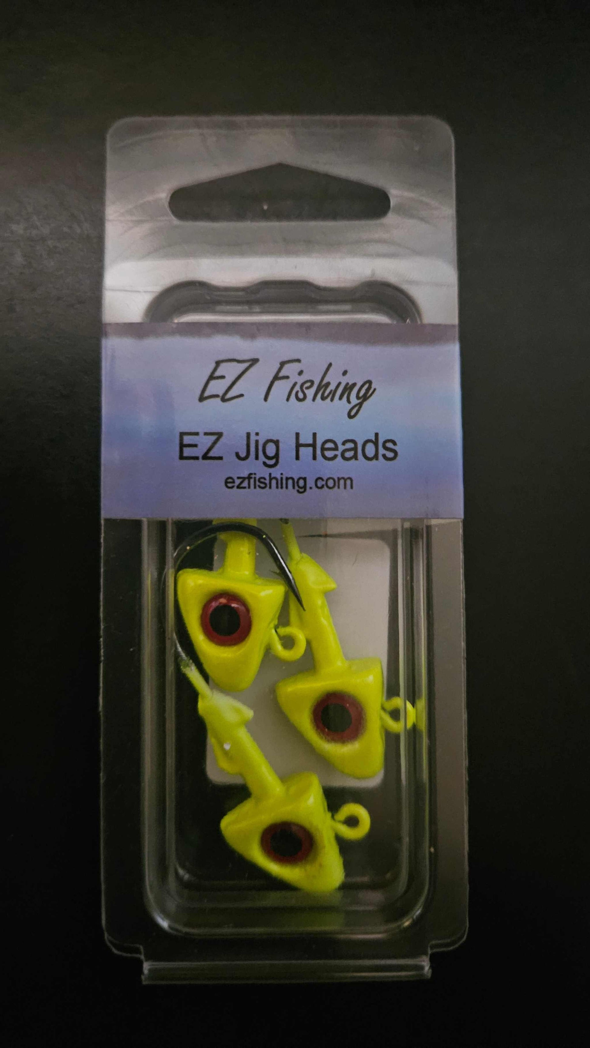 A picture showing a package of 3 EZ Jig Heads, ½ oz, Yellow with red eyes and 3/0 HooksA picture showing a packge of 3 EZ Jig Heads, ½ oz, Yellow with red eyes and 3/0 Hooks