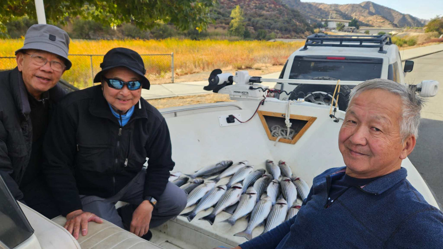 Guide Service, 3 men sitting in a boat showing their catch