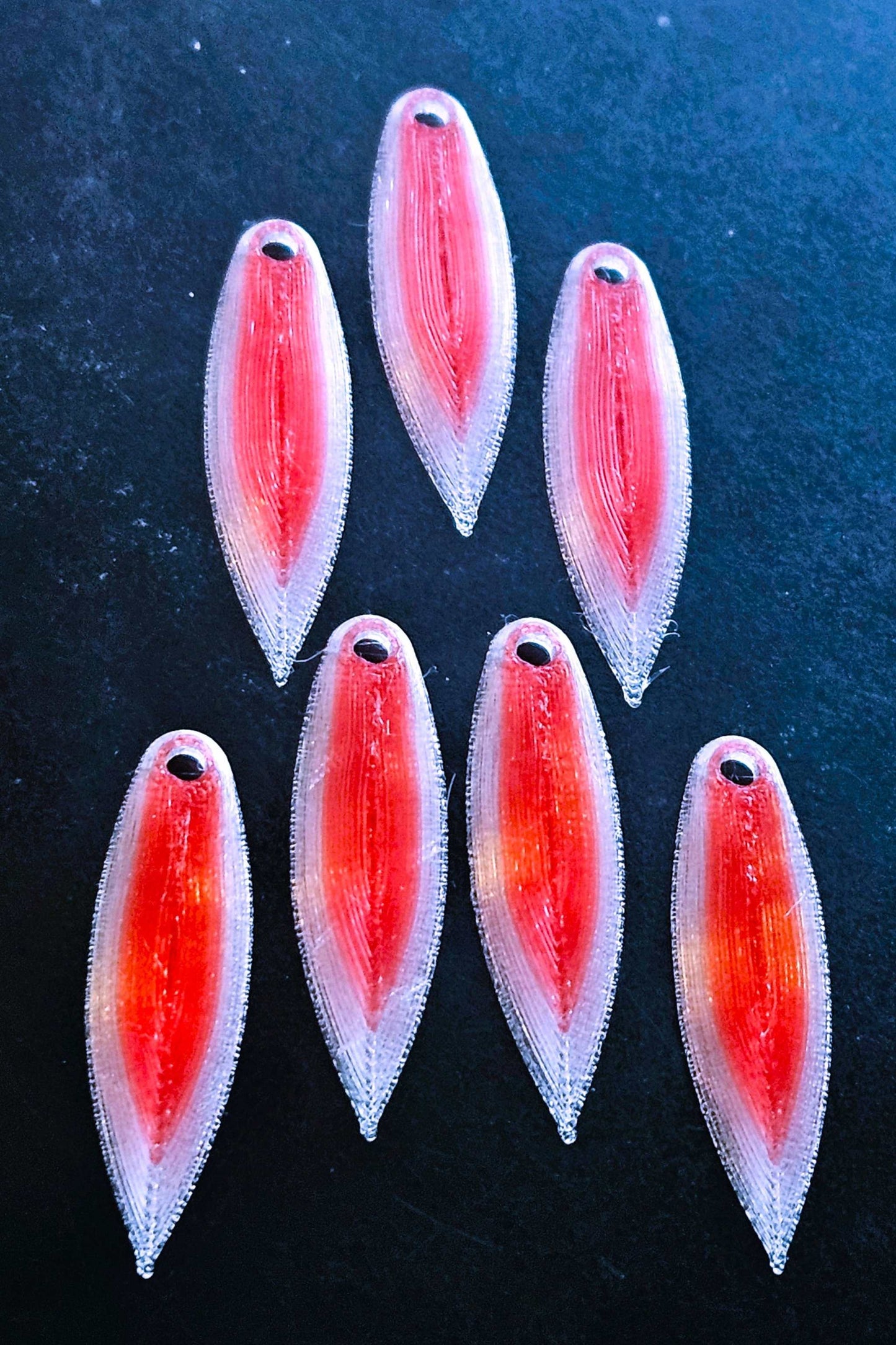 a picture showing 7 Red with a White border EZ Fishing 1.75" EZ TPU Spinner Blades